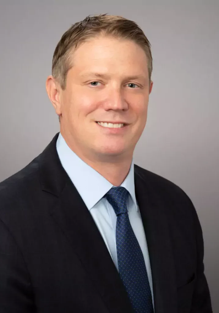 Professional man in a suit smiling at the camera.
